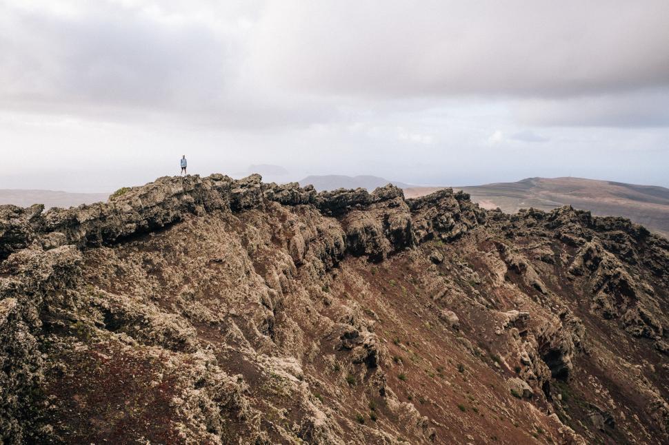 Free Image of Person Standing on Top of Rocky Mountain 