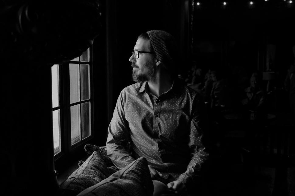 Free Image of Man Sitting in Chair Looking Out Window 