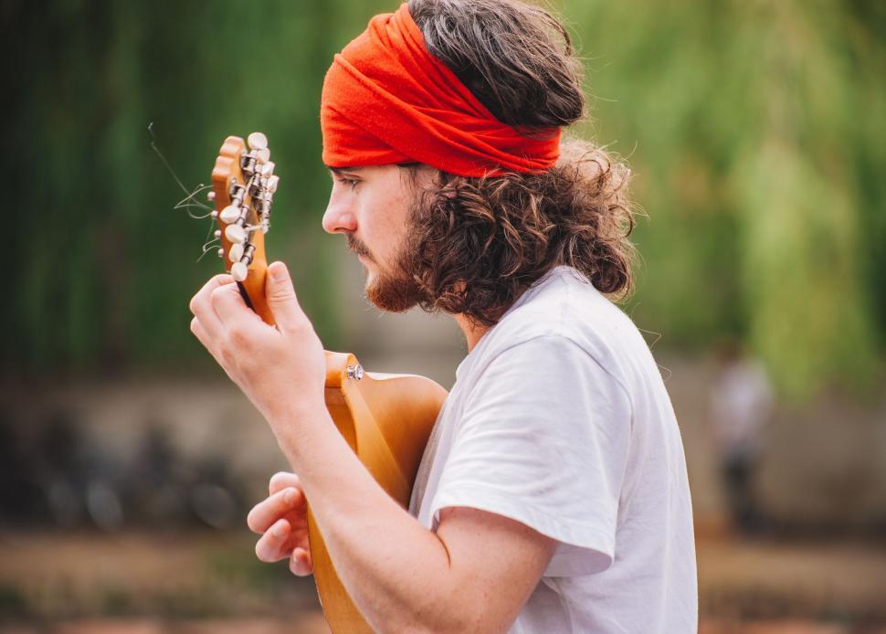 Free Image of Man Playing Guitar With Red Bandana 