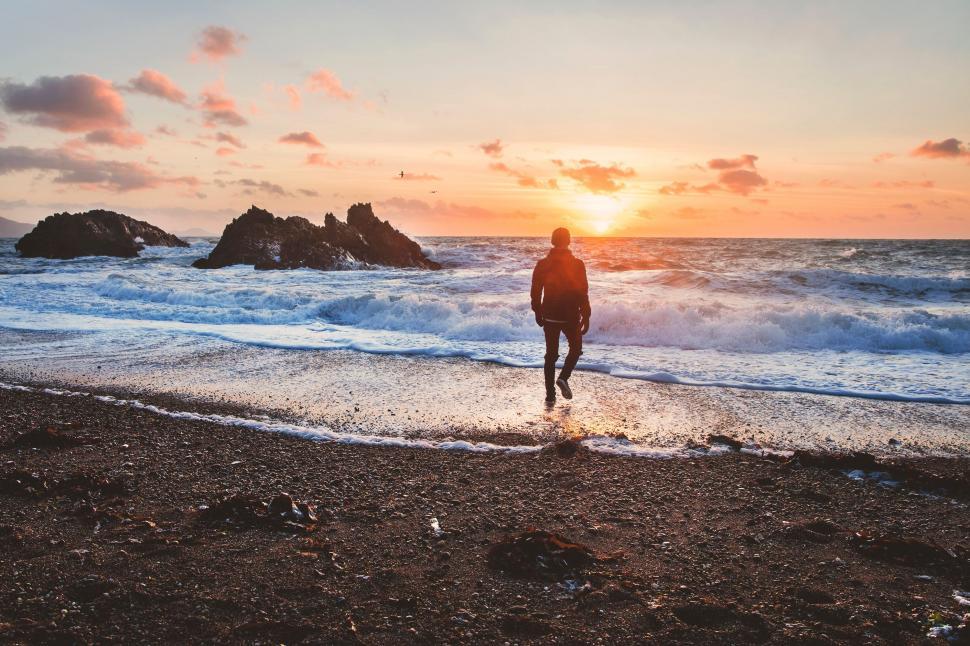 Free Image of Person Walking on Beach at Sunset 