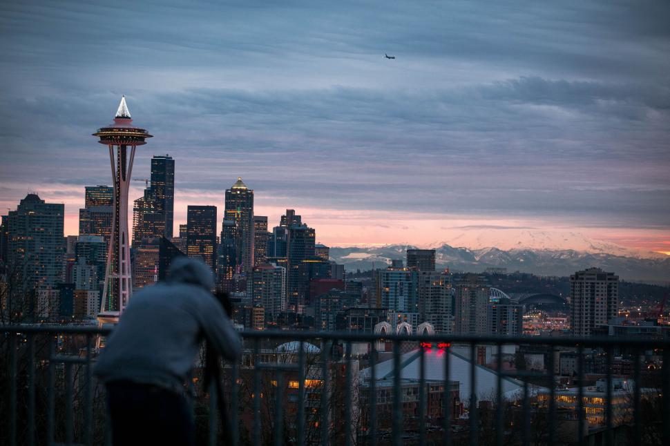 Free Image of Man Standing on Balcony Next to Tall Building 