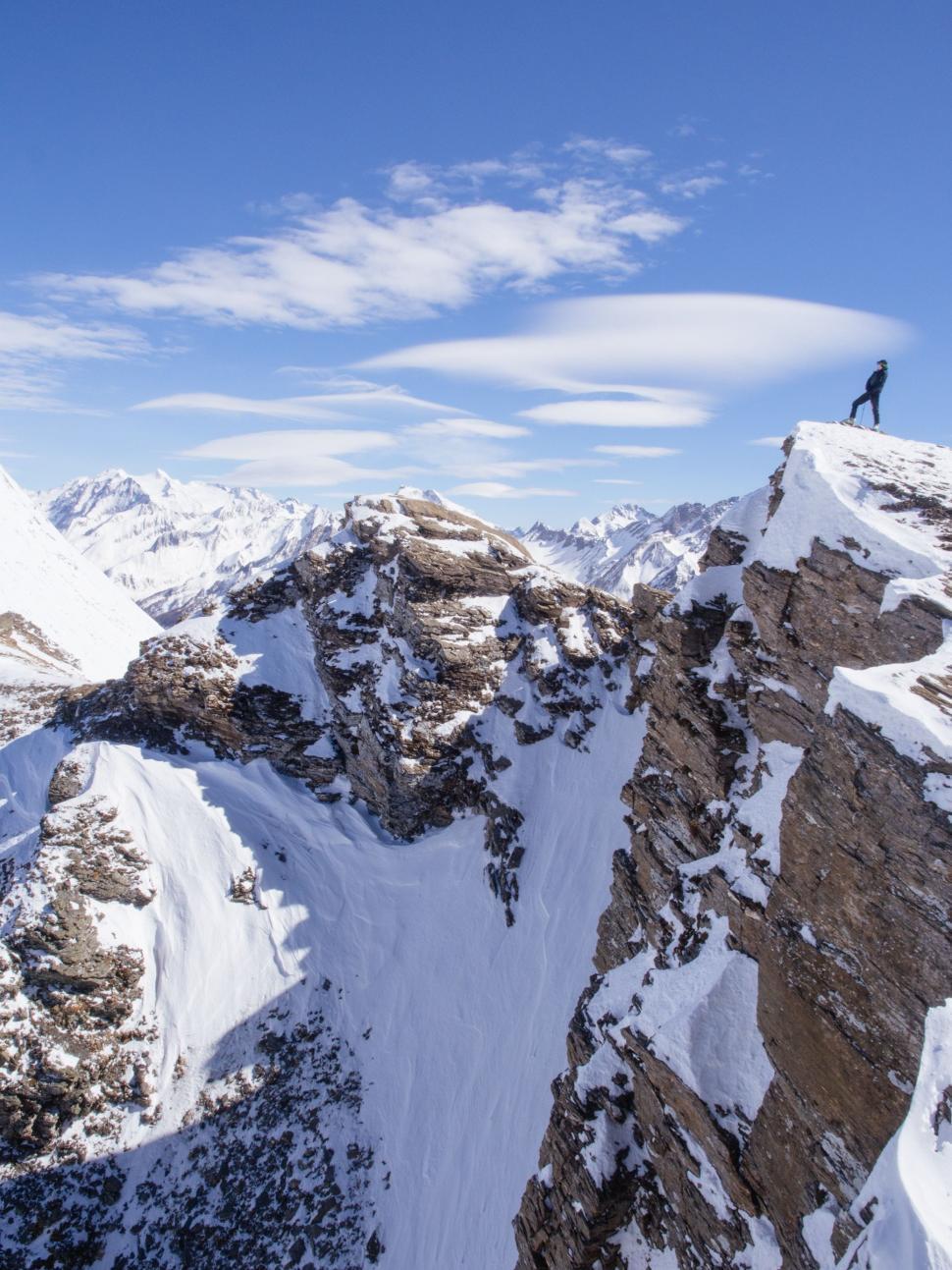 Free Image of Man Standing on Top of Snow Covered Mountain 
