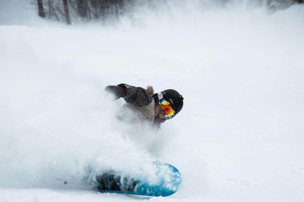 Free Image of Man Snowboarding Down Snow Covered Slope 