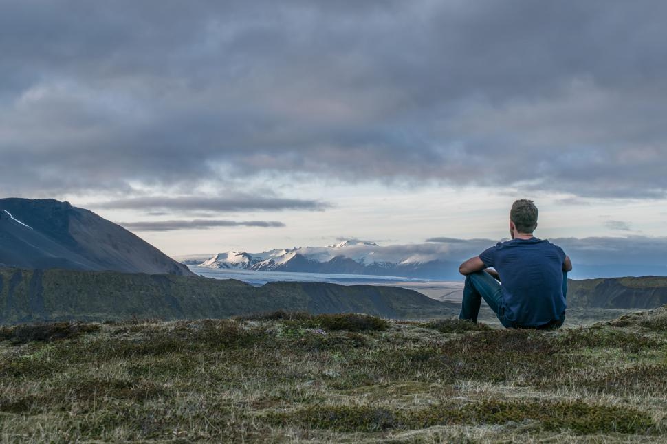 Free Image of Man Sitting on Top of Grass Covered Hill 