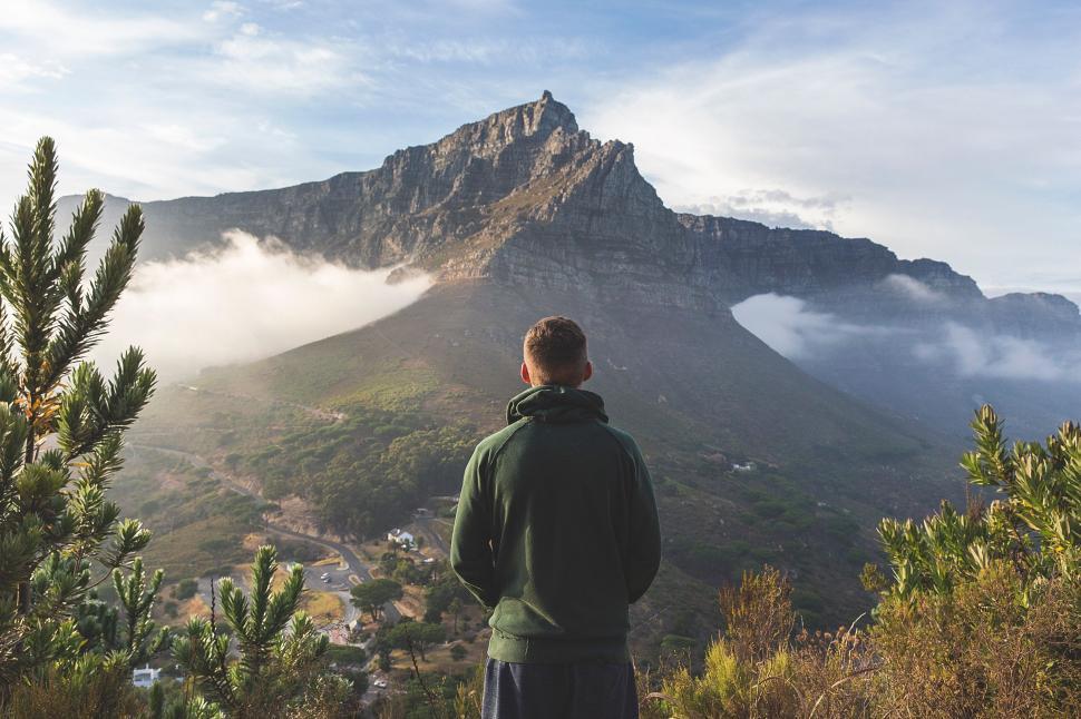 Free Image of Man Standing on Top of Lush Green Hillside 