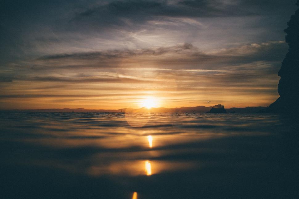 Free Image of Sun Setting Over Clouds in Sky 