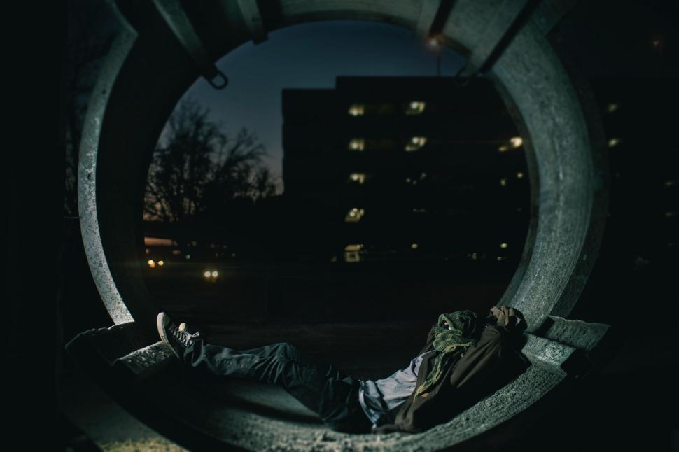Free Image of Man Laying on Bench in the Dark 