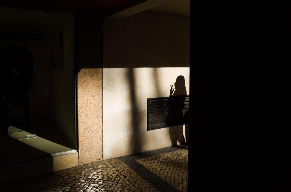 Free Image of Person Standing in the Shadows of a Building 