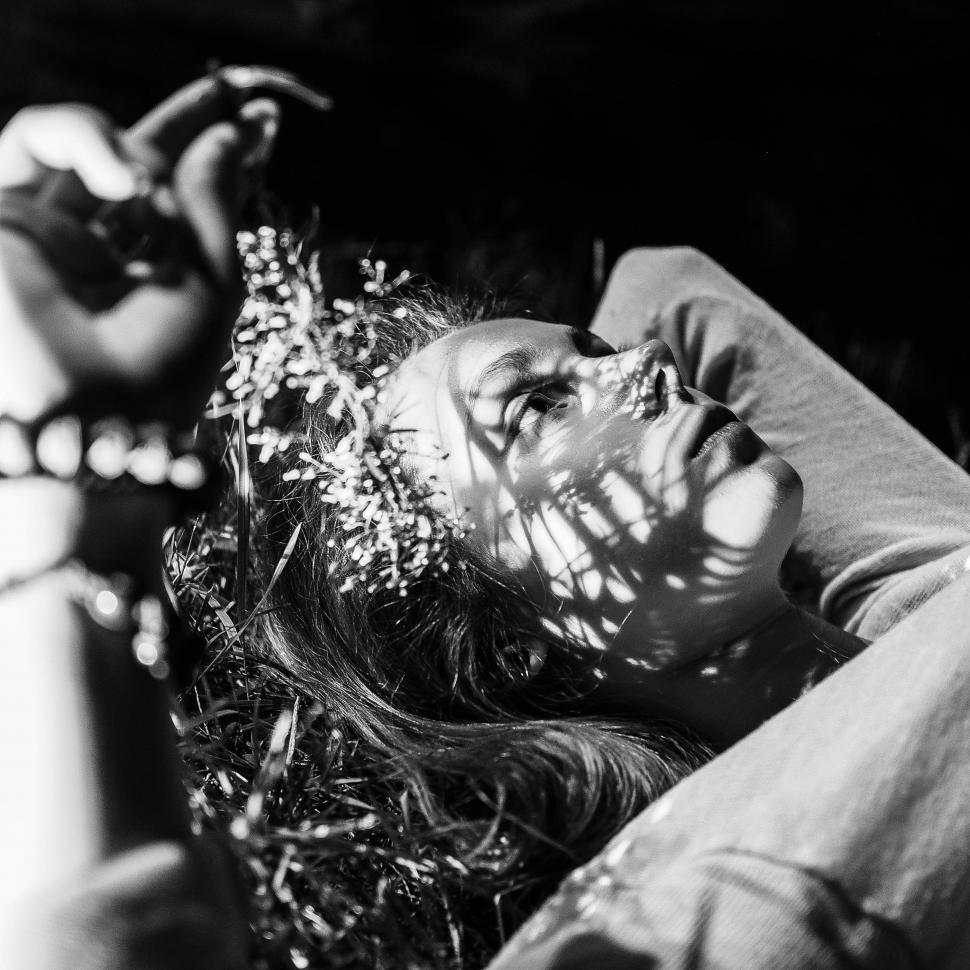 Free Image of Woman Laying on Ground With Flower in Hair 