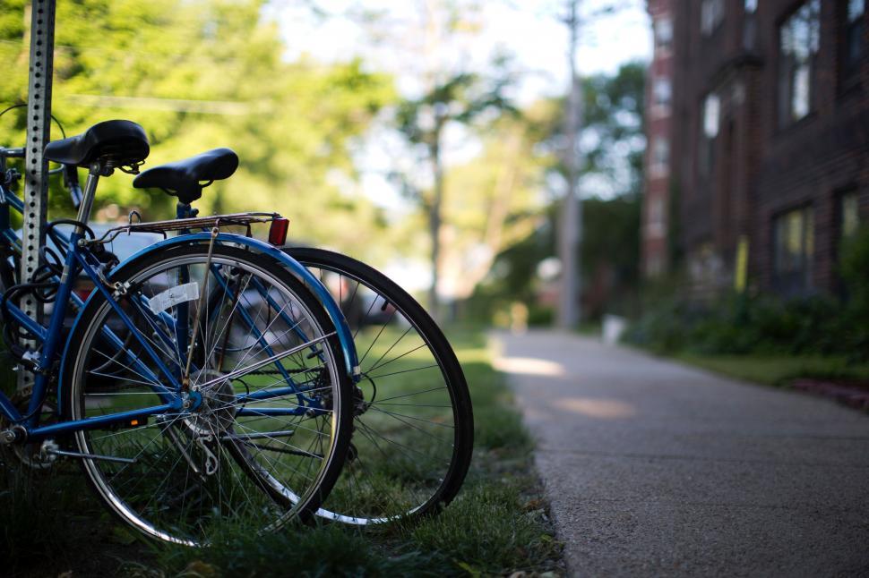 Free Image of Blue Bike Parked Next to Pole on Side of Road 