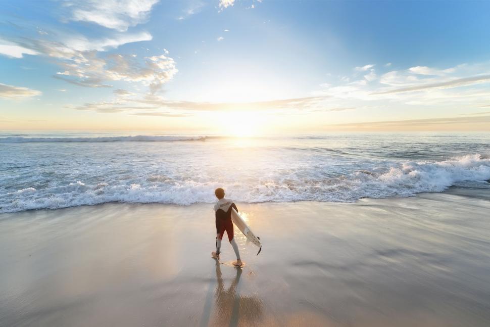 Free Image of Person Walking on Beach With Surfboard 