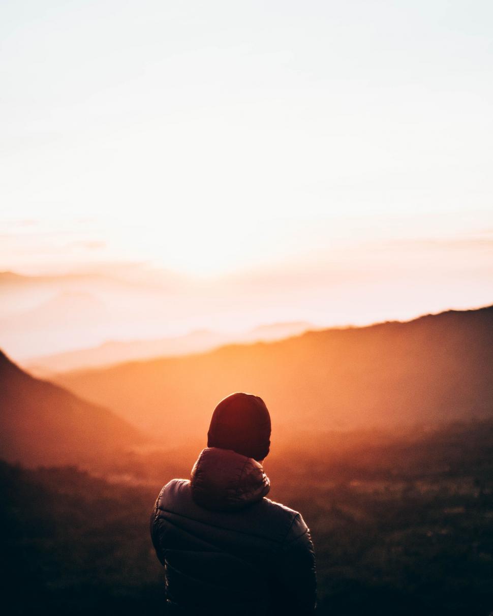 Free Image of Person Standing on Top of a Mountain at Sunset 