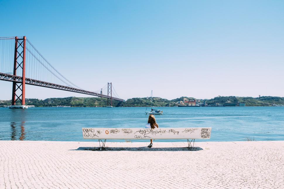 Free Image of Person Sitting on Bench by Water 