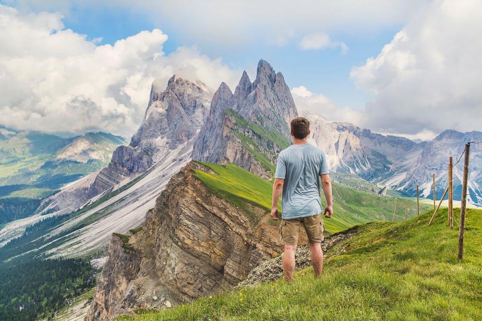 Free Image of Man Standing on Top of Lush Green Hillside 