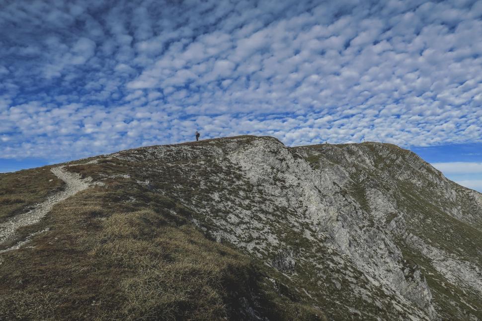 Free Image of Person Standing on Snow Covered Mountain Summit 