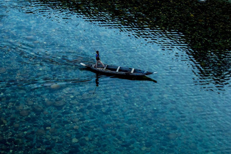 Free Image of Small Boat Floating on Top of Body of Water 
