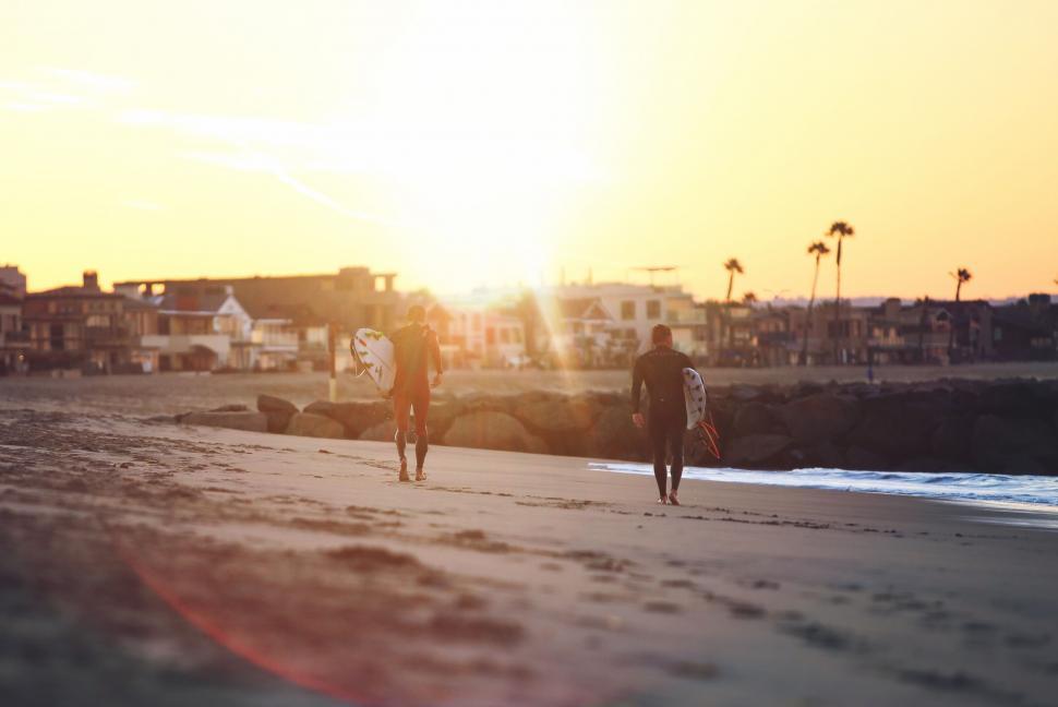 Free Image of Couple Walking Down Beach Along Ocean 