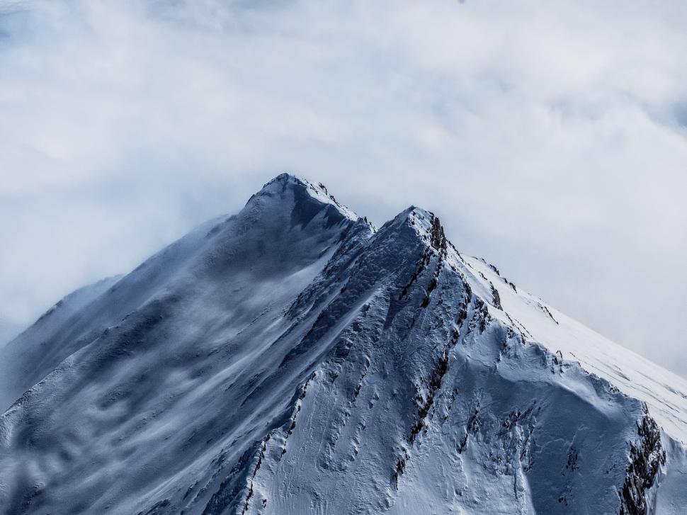 Free Image of Snow Covered Mountain Under Cloudy Sky 