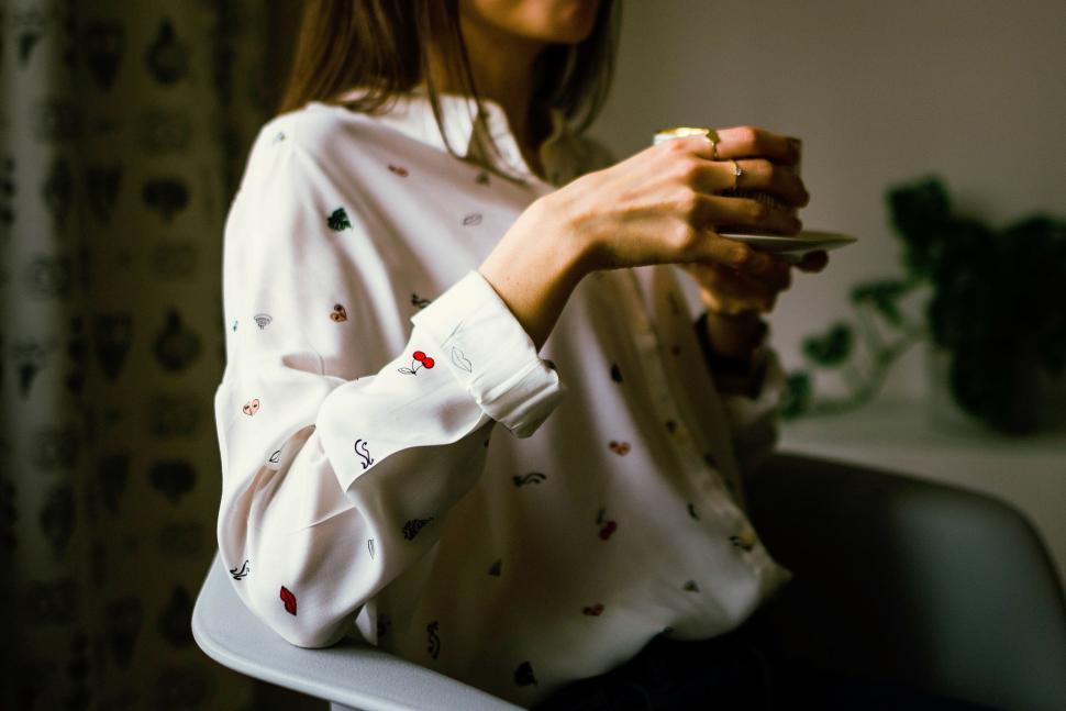 Free Image of Woman Holding Coffee Cup in Chair 