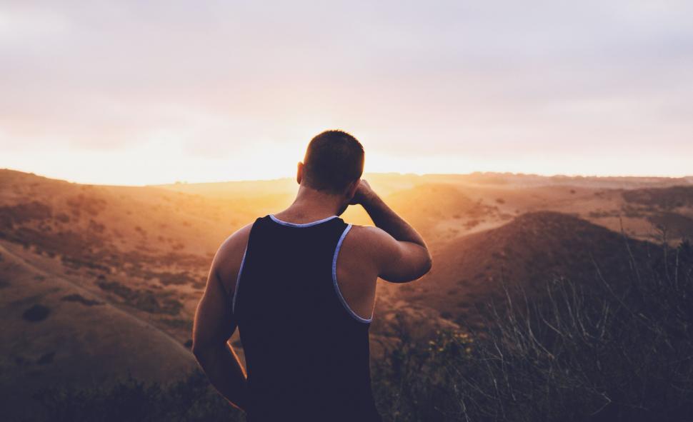 Free Image of Man Standing on Top of Lush Green Hillside 