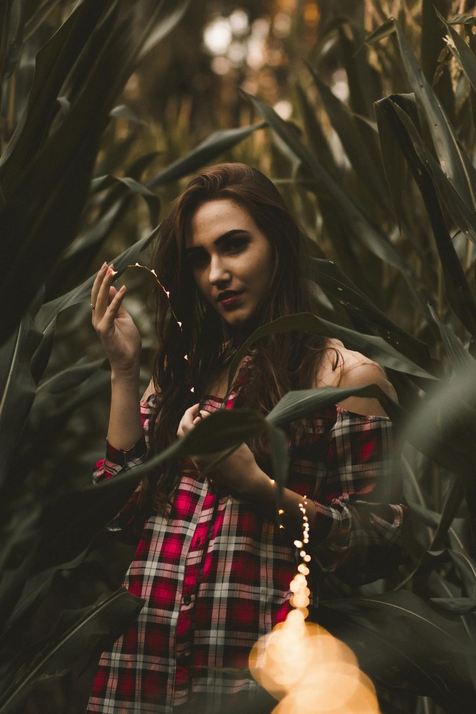 Free Image of Woman in Red and Black Dress Standing in Forest 