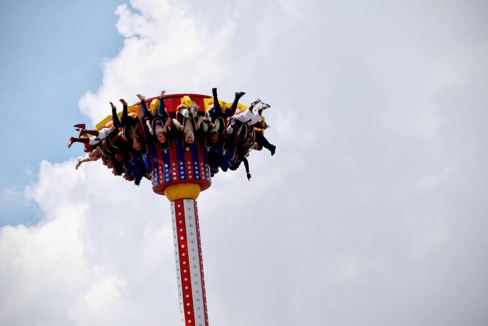 Free Image of Group of People Riding on Top of a Roller Coaster 