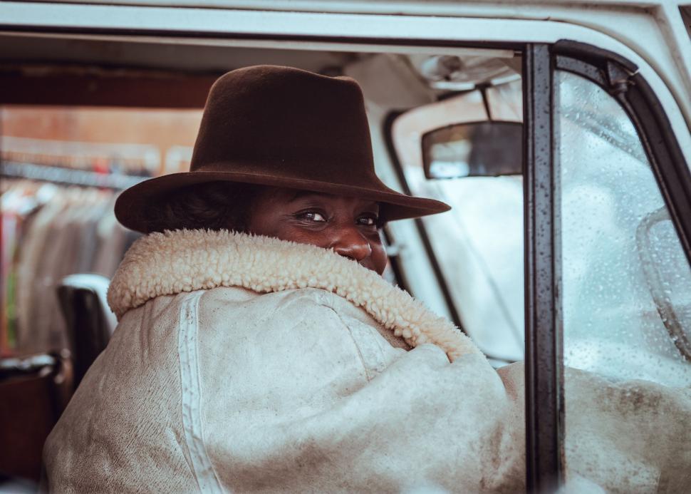 Free Image of Woman in White Coat and Hat Sitting in Car 