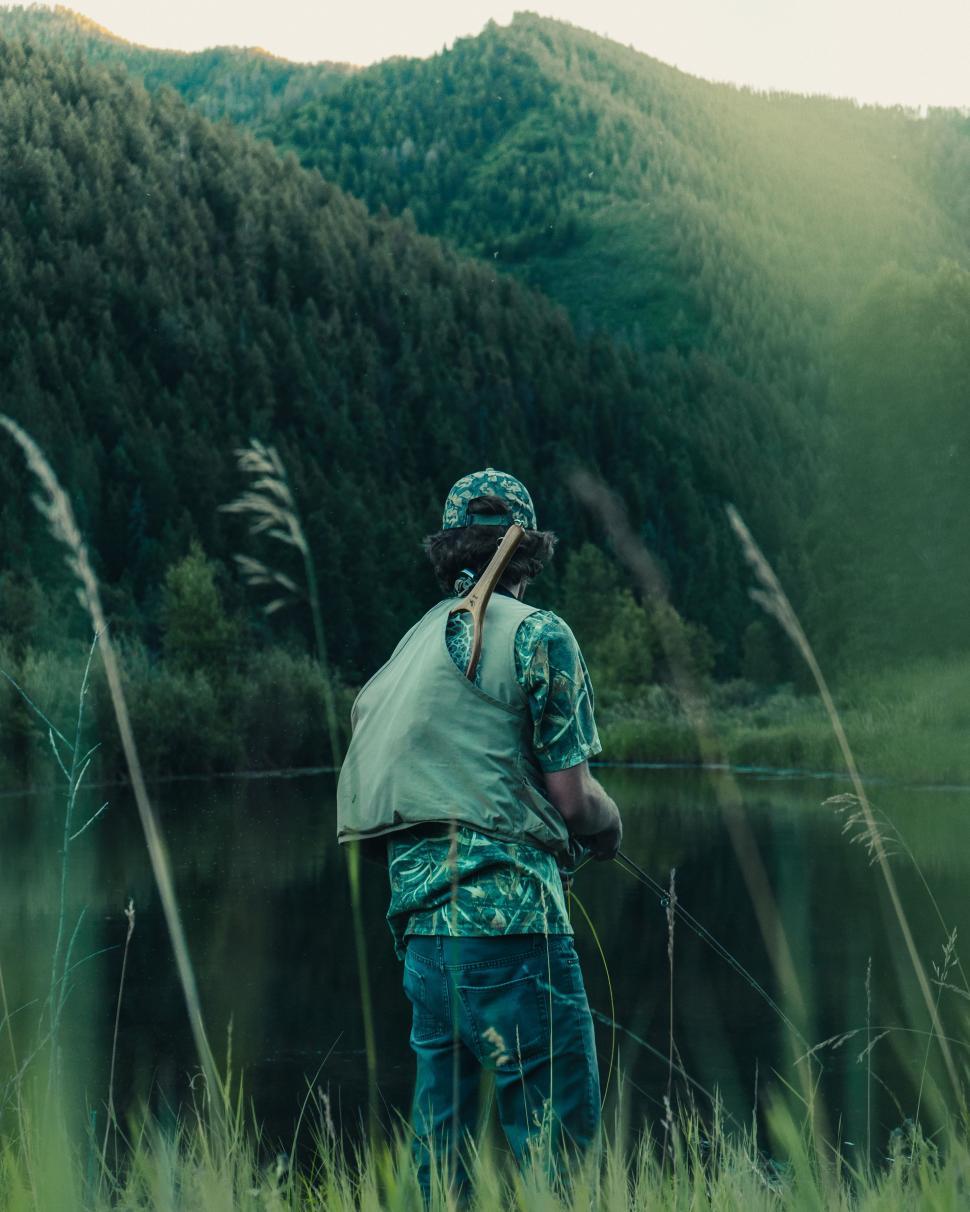 Free Image of Man Standing in Tall Grass by Lake 