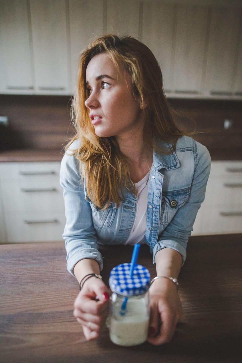 Free Image of Woman Sitting at Table With Glass of Milk 