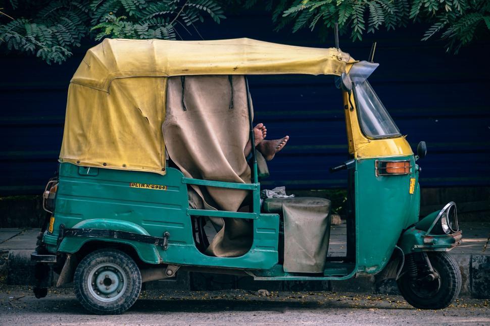 Free Image of Green and Yellow Three-Wheeled Vehicle Parked Next to Tree 