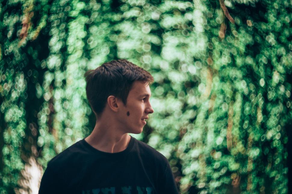Free Image of Man Standing in Front of Green Wall 