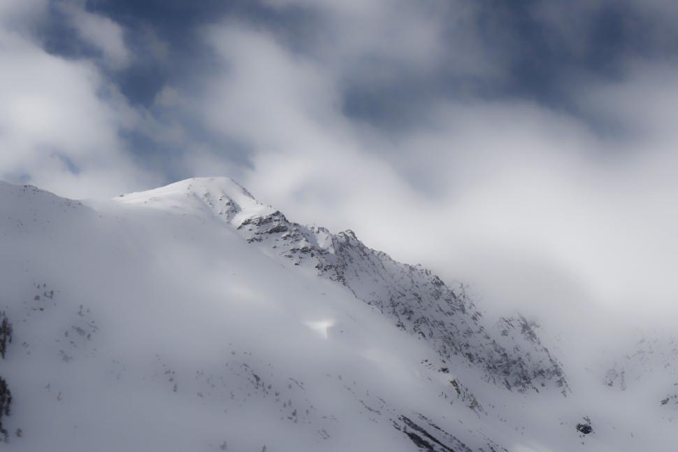 Free Image of Snow-Covered Mountain Under Cloudy Sky 