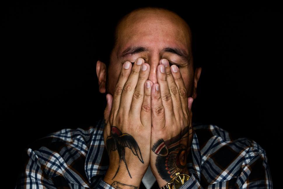 Free Image of Man Covering Face With Hands 