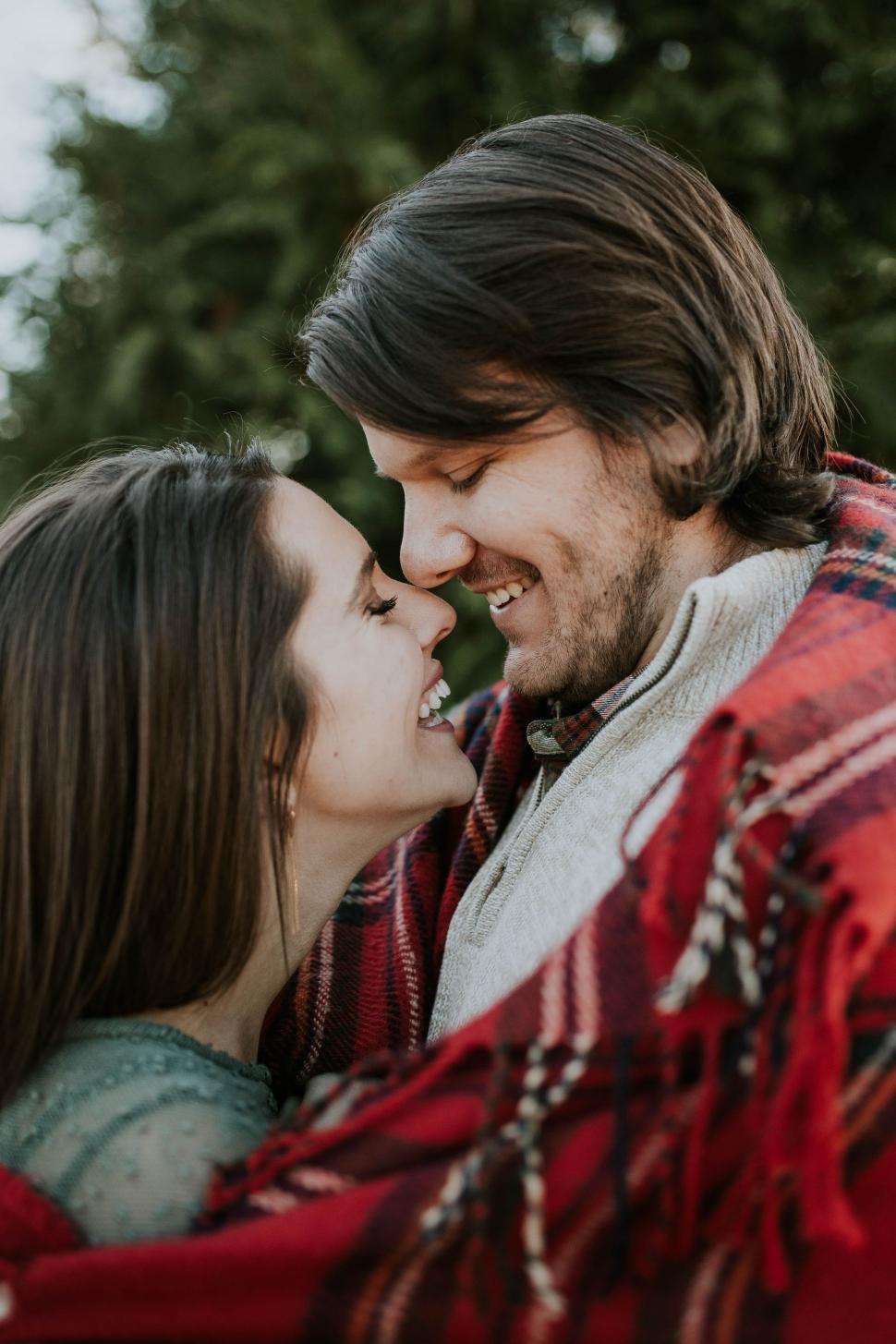 Free Image of Couple Sharing a Kiss Wrapped in a Blanket 