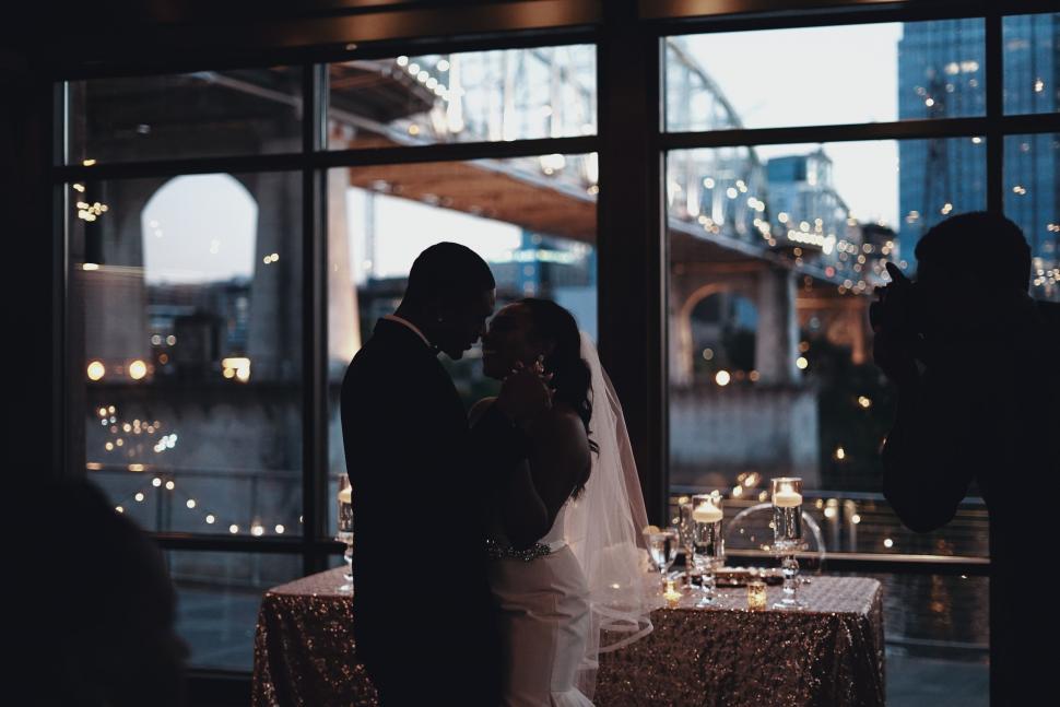 Free Image of Bride and Groom Standing in Front of Window 