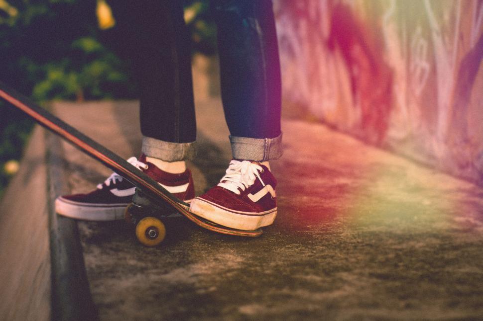 Free Image of Person Standing on Skateboard in Front of Wall 