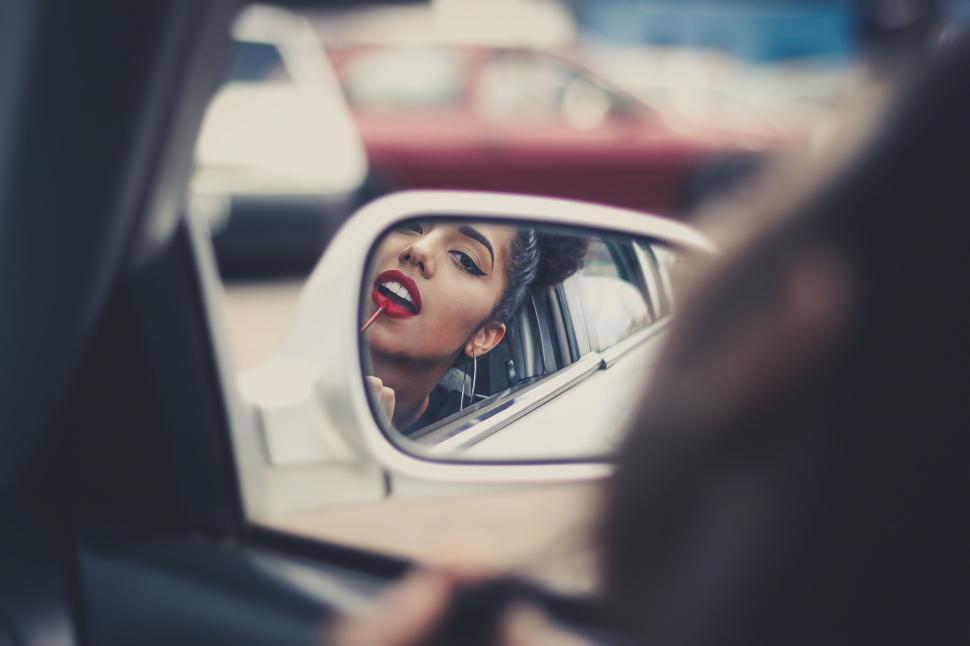 Free Image of Womans Face Reflected in Car Side View Mirror 