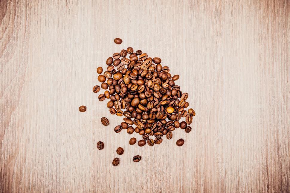 Free Image of A Pile of Coffee Beans on a Wooden Table 