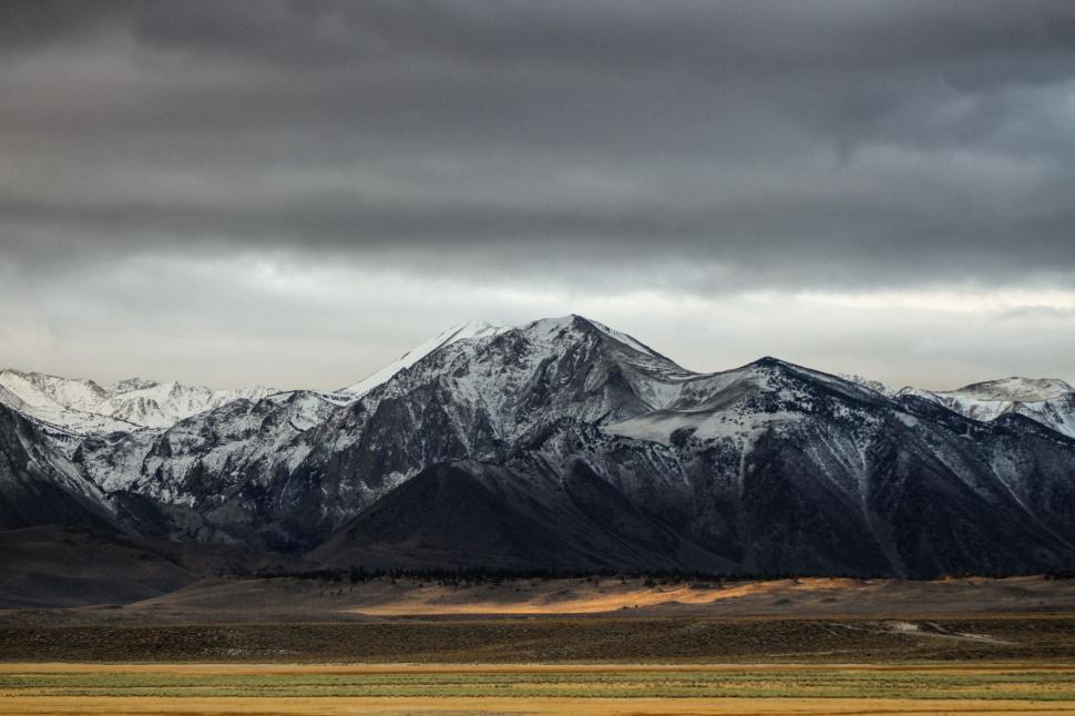Free Image of Snow-Covered Mountains Under Cloudy Sky 