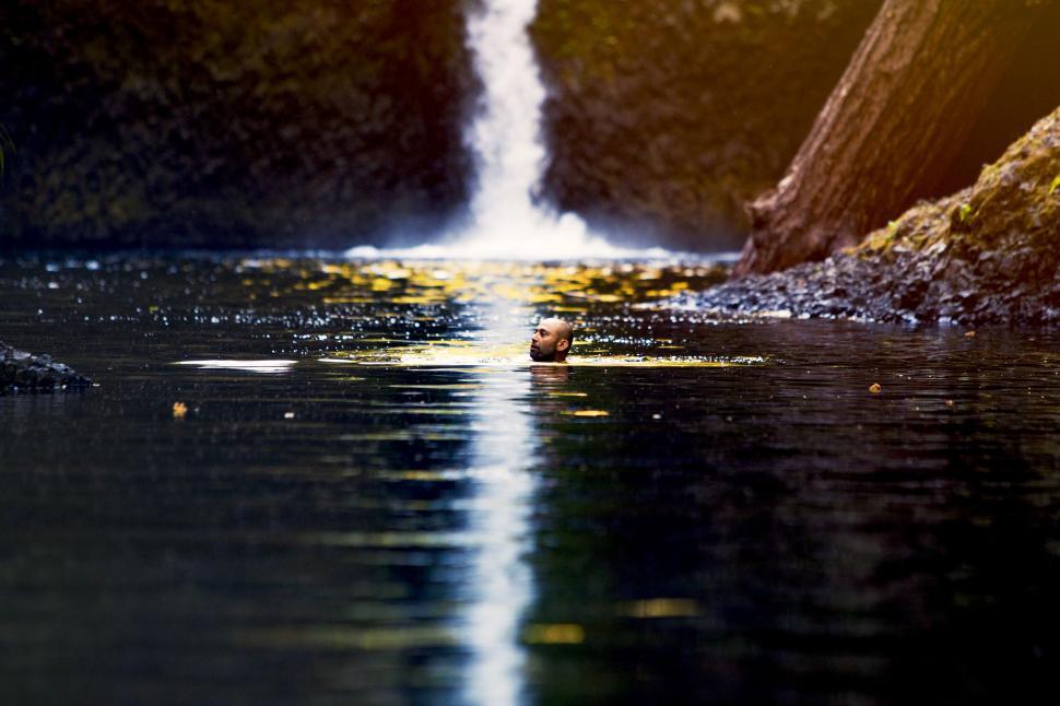 Free Image of Small Waterfall Flowing Into Body of Water 