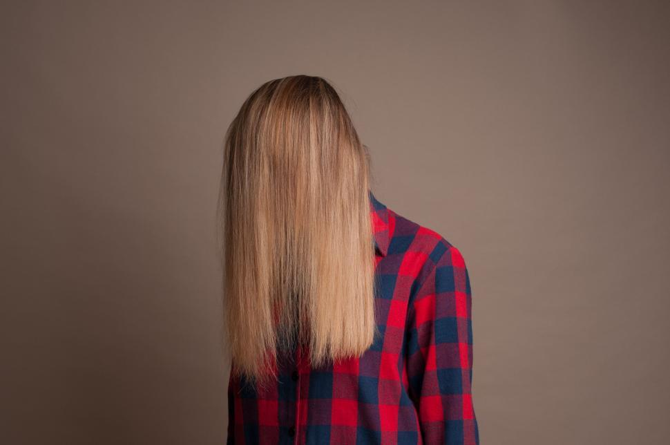 Free Image of Woman With Long Blonde Hair in Front of Wall 