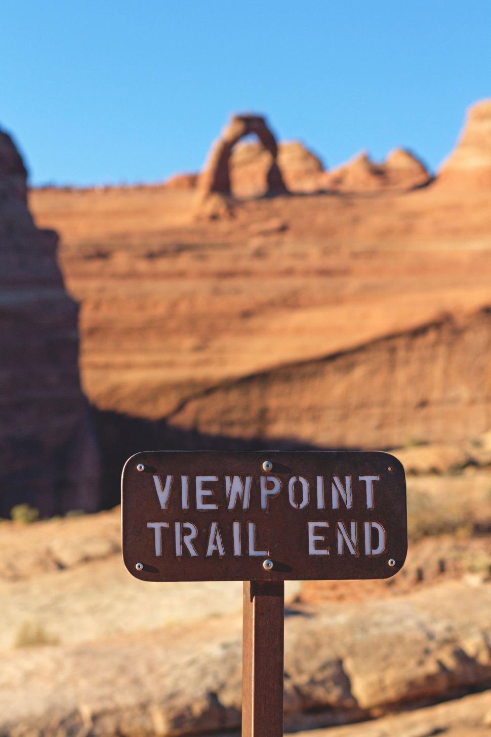 Free Image of Trail Sign in Front of Rock Formation 