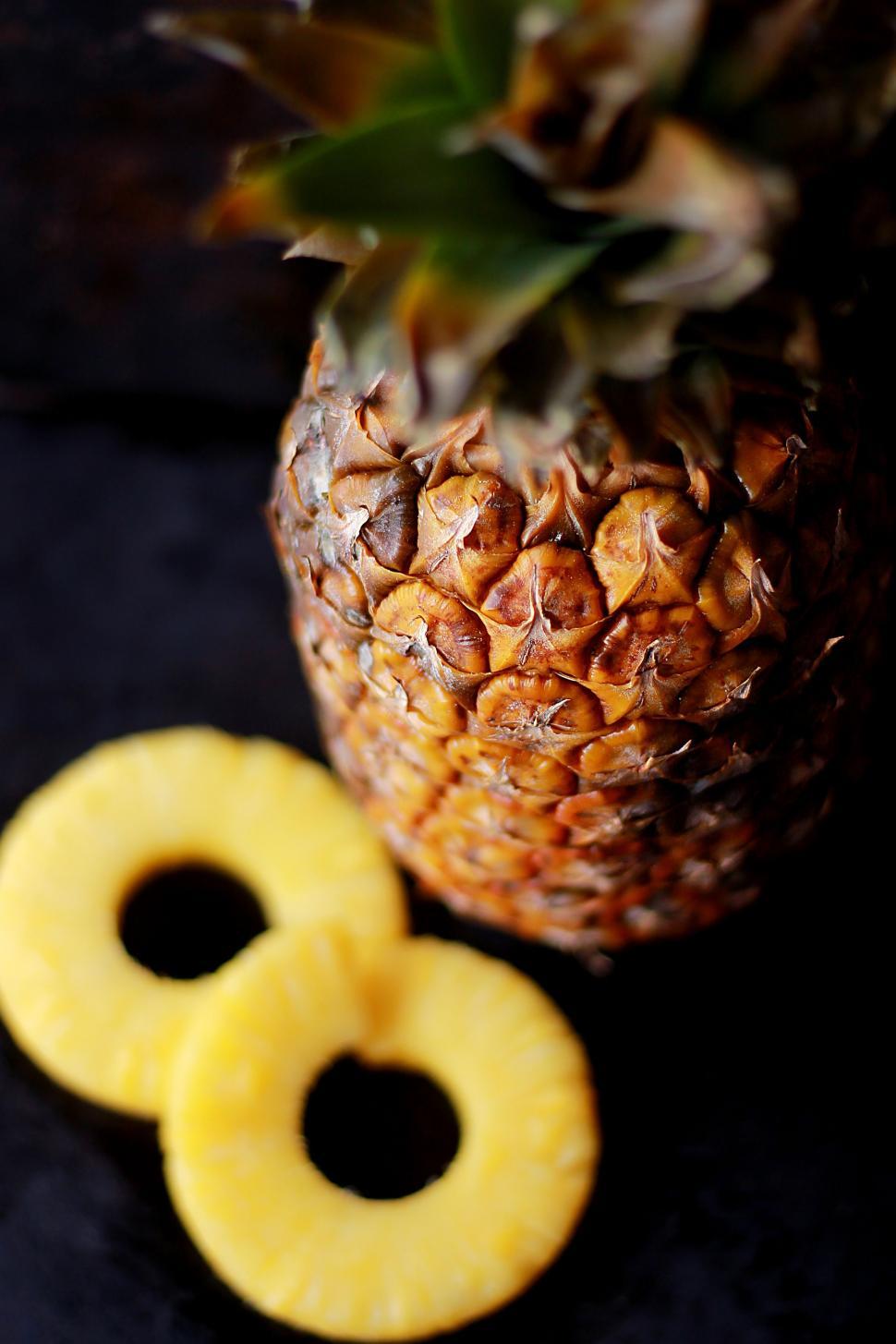 Free Image of Pineapple and Two Slices on Table 