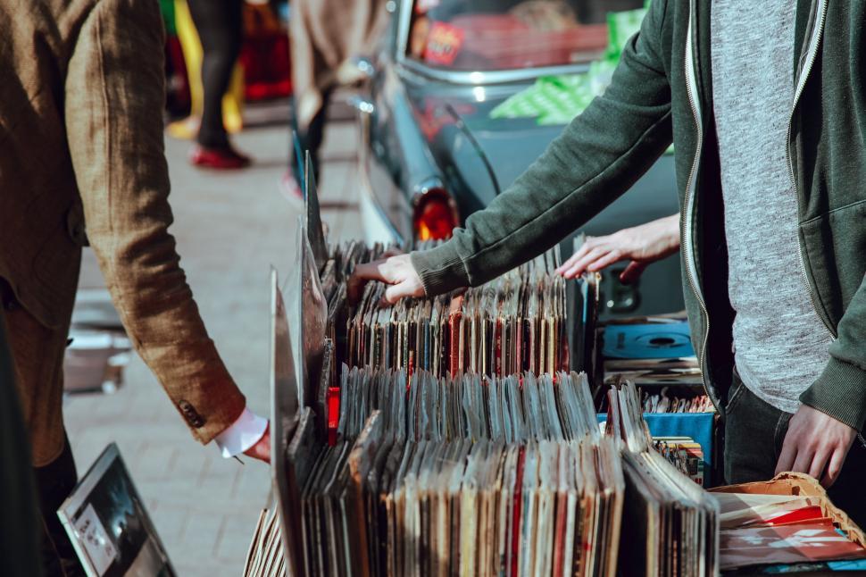 Free Image of Man Standing Next to Pile of Records 