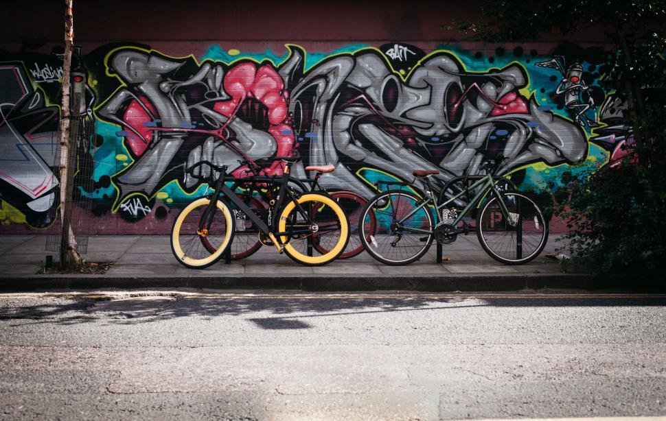 Free Image of Bikes Parked in Front of Graffiti Wall 