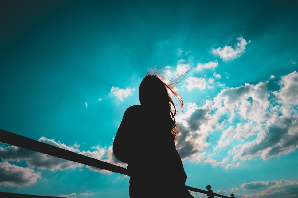 Free Image of Woman Standing on Bridge Looking at Sky 