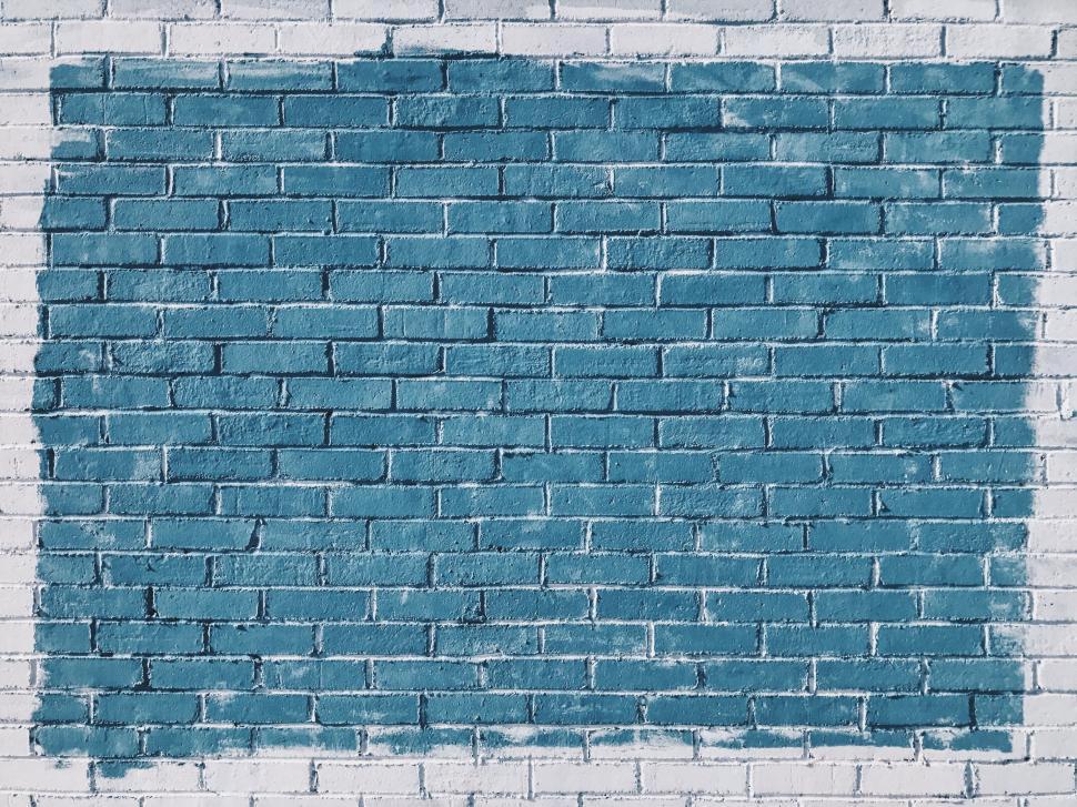 Free Image of Blue Brick Wall Being Painted With Paint Roller 