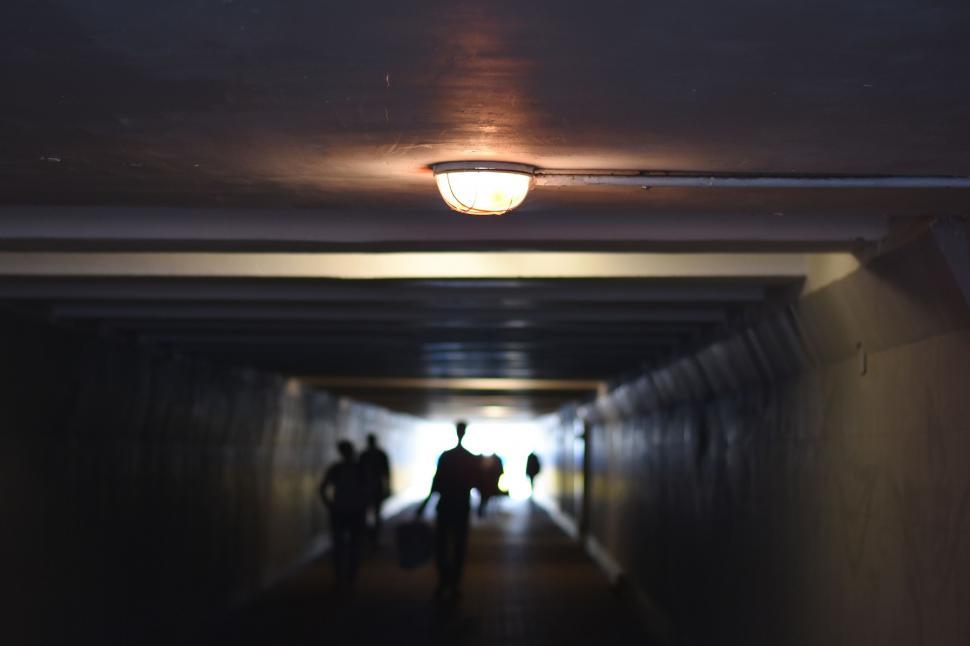 Free Image of Group of People Walking Down a Dark Hallway 