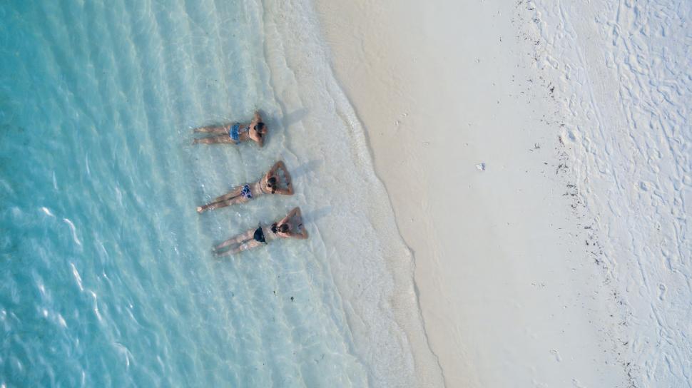 Free Image of Group of People Floating on Top of a Body of Water 
