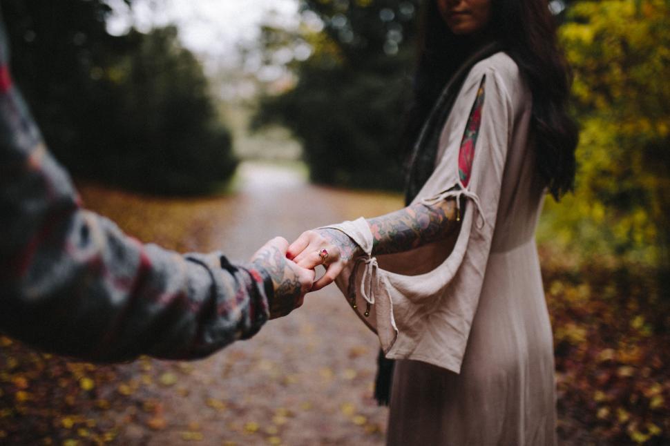 Free Image of A Man and a Woman Holding Hands on a Path 